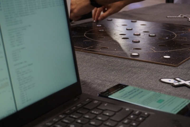 A smartphone, a laptop computer and the prototype of a board game