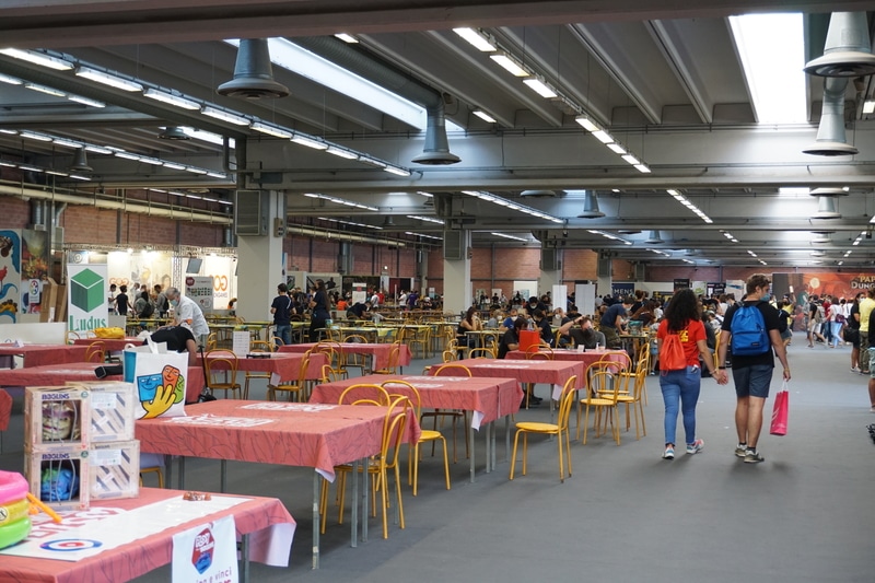 One of the halls of a board game festival shortly after opening. Many tables are still unattended.